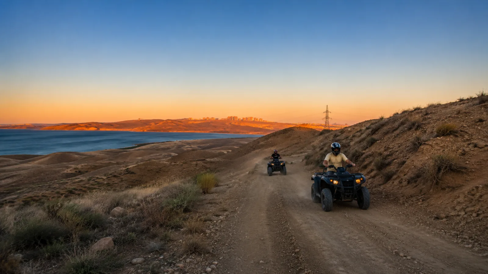Quad bikes on a coastal ridge track above the Caspian at sunset near Baku